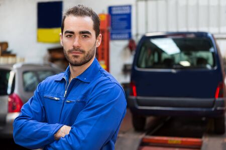 View of a Young attractive mechanic working at the garageの写真素材