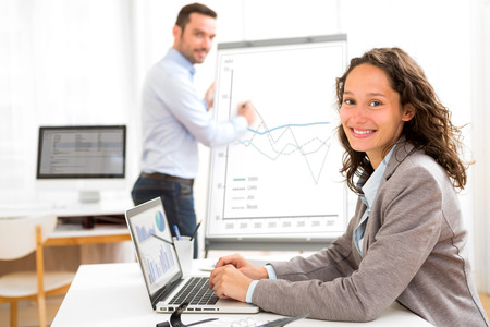 View of a Business man and woman analysing stats while doing video conferenceの写真素材