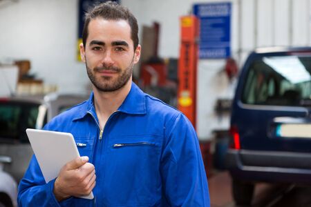 View of a Young attractive mechanic working at the garageの写真素材