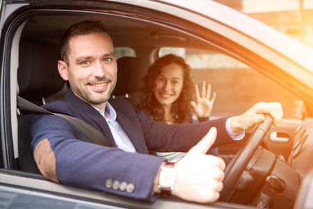 View of a Young business man couple in their brand new car