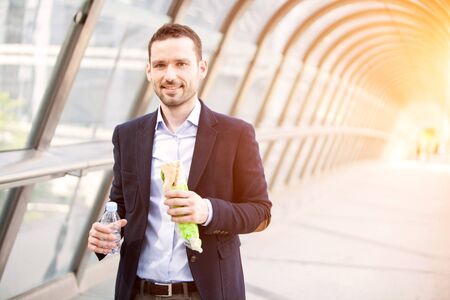 View of a Young attractive man eating fast his lunchの写真素材