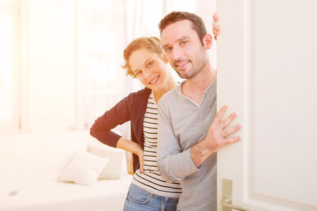 View of a Young attractive couple welcoming you in his houseの写真素材