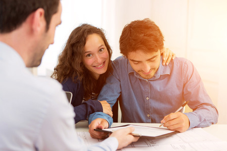 View of a Young attractive couple signing contractの写真素材