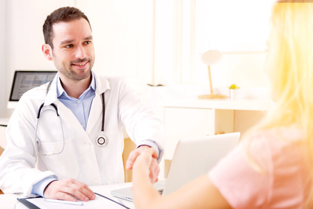 View of a Young attractive doctor listening his patientの写真素材