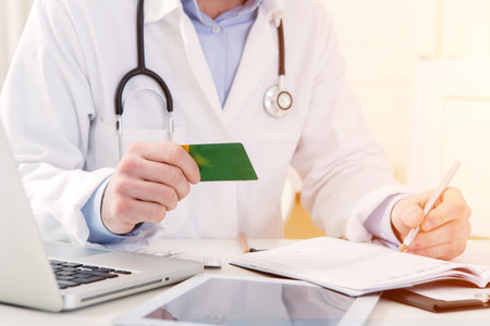 View of a Young attractive doctor taking health insurance cardの写真素材