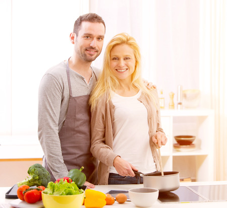 View of a Young attractive couple cooking in a kitchenの写真素材