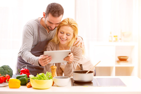 View of a Young attractive couple cooking in a kitchenの写真素材