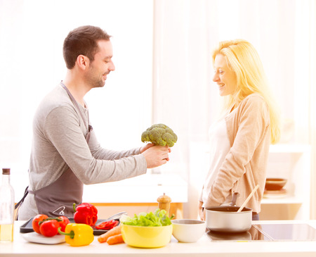 View of a Young attractive couple cooking in a kitchenの写真素材