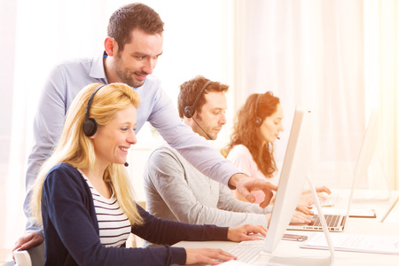 View of a Manager training a young attractive people on computerの写真素材