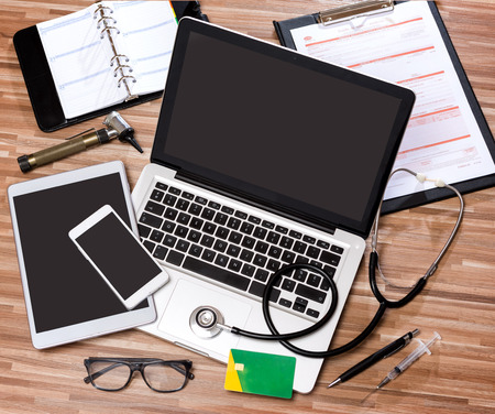 View of a Wood doctor's desk in high definition with laptop, tablet and mobile phoneの写真素材