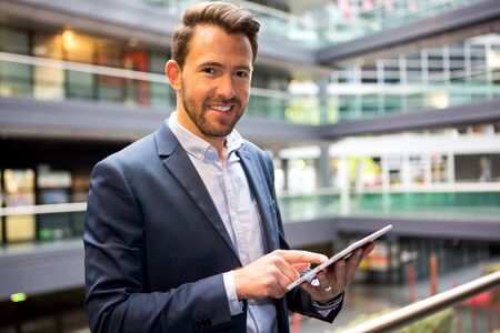 View of a Young attractive business man using tabletの写真素材
