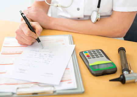 View of a doctor filling a prescription to a patientの写真素材