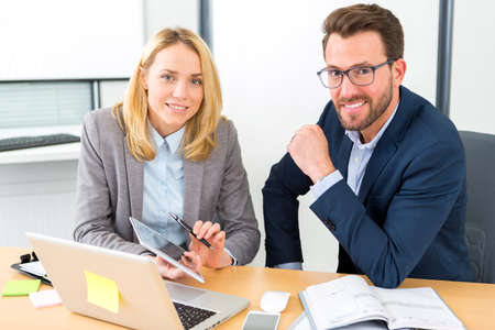 View of a Businessman and his assistant working together at the officeの写真素材