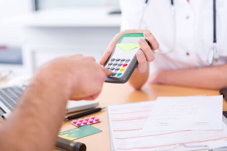 View of somebody paying doctor by credit cardの写真素材