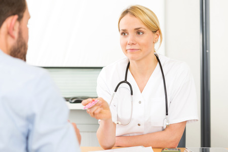 View of a Young attractive woman doctor giving pills to a patientの写真素材