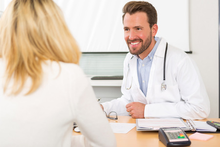 View of a Young attractive doctor listening his patientの写真素材