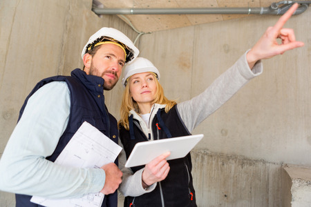 View of Two workers checking last details on a construction siteの写真素材