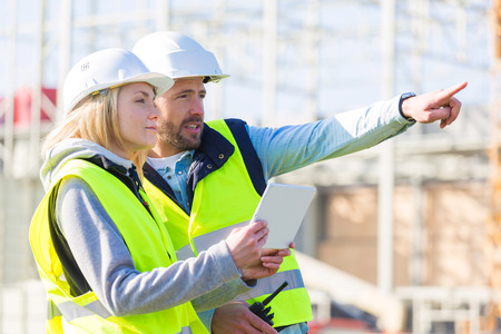 View of Two workers working outside with a tablet on a construction siteの写真素材