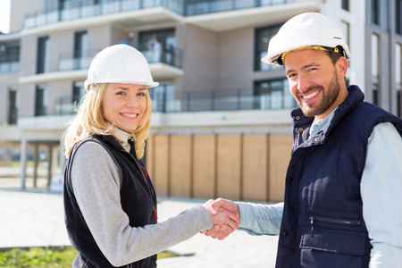 View of an architect and worker handshaking on construction siteの写真素材