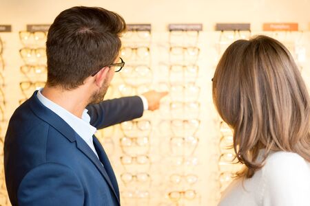 View of a Young attractive  woman testing new glasses with opticianの写真素材