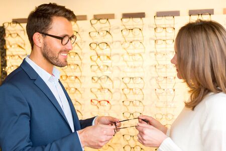 View of a Young attractive  woman testing new glasses with opticianの写真素材