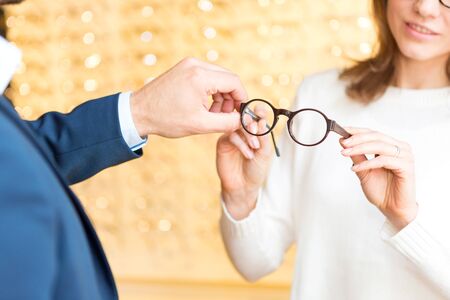 View of a Young attractive  woman testing new glasses with opticianの写真素材
