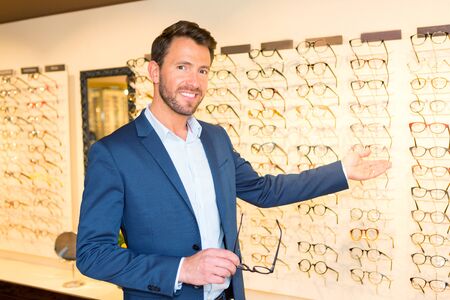 View of a Attractive optician working in his glasses shopの写真素材