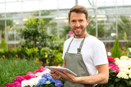 View of a Young attractive man working at the plants nursery using tabletの写真素材
