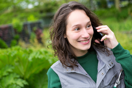 View of a Young attractive woman working in a public garden using mobileの写真素材