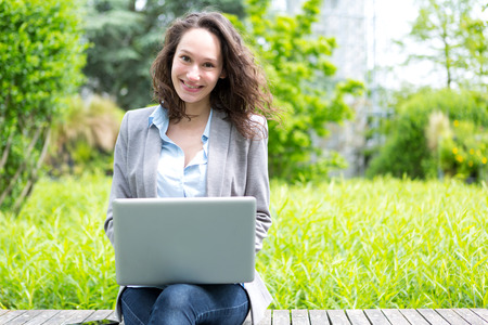 View of a Young attractive business woman working at the park during a pauseの写真素材