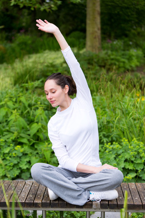 View of a Young attractive woman practising yoga in a parkの写真素材