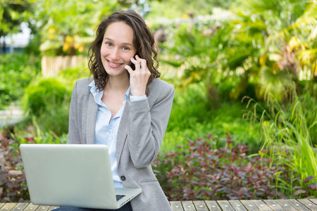 View of a Young attractive business woman working at the park during a pauseの写真素材