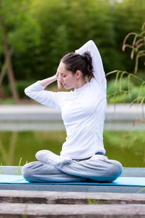 View of a Young attractive woman practising yoga in a parkの写真素材
