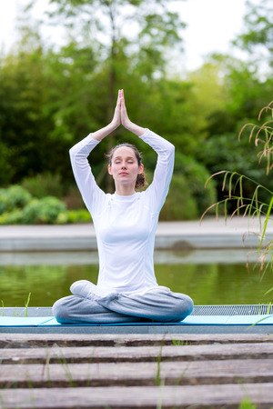 View of a Young attractive woman practising yoga in a parkの写真素材