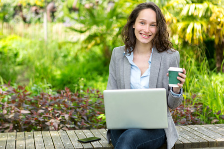 View of a Young attractive business woman working at the park during a pauseの写真素材