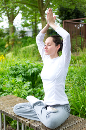 View of a Young attractive woman practising yoga in a parkの写真素材