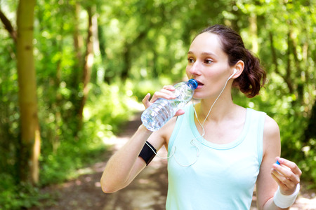 View of a Young attractive woman drinking water after a running sessionの写真素材