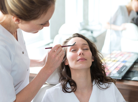 View of Two young beautician students working during make up classes