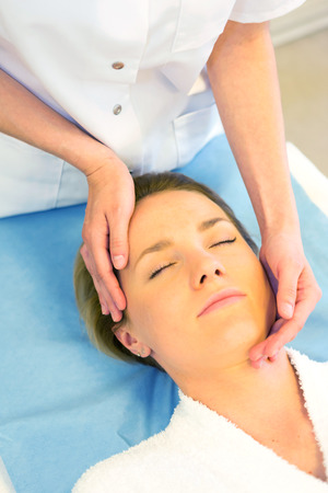 View of a Detail of a woman face receiving a relaxing facial massageの写真素材