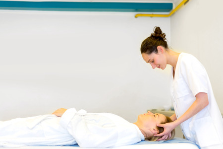 View of a Young attractive masseuse doing a capillariy massageの写真素材