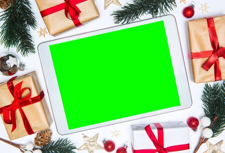 Tablet in a Christmas white background view with tree gift and decorationの写真素材
