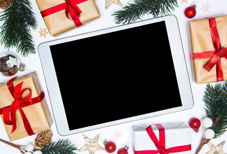 Tablet in a Christmas white background view with tree gift and decorationの写真素材