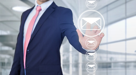 View of a Businessman touching technology interface with professional email iconの写真素材