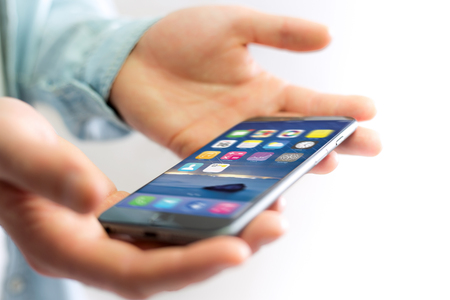 View of a Hand holding black smartphone with operating system screenの写真素材