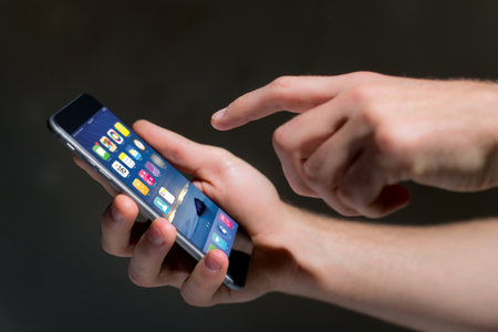 View of a Hand holding black smartphone with operating system screenの写真素材