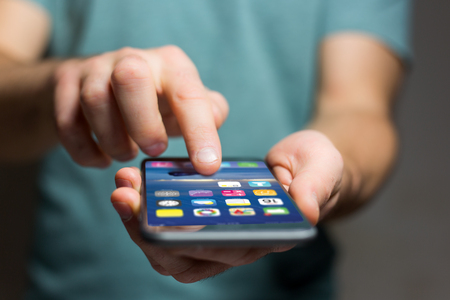 View of a Hand holding black smartphone with operating system screenの写真素材