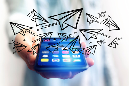 Concept view of creativity with flying paper plane over a smartphoneの写真素材