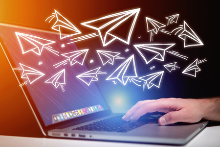 Concept view of creativity with flying paper plane over a laptopの写真素材