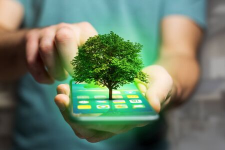 View of a Green tree going out of a smartphone - Ecology concept
