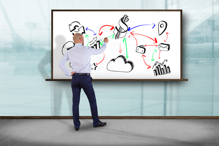 View of a Businessman in front of a wall writing on a business reminder interface application - Technology conceptの写真素材